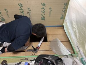 埼玉県さいたま市などで害獣駆除を行う「すぐくる総合リビングサービス」の防除作業従事者が、床下のネズミ侵入口を専用コーキング剤とパンチングメタル(金網)で封鎖するプロの作業風景。